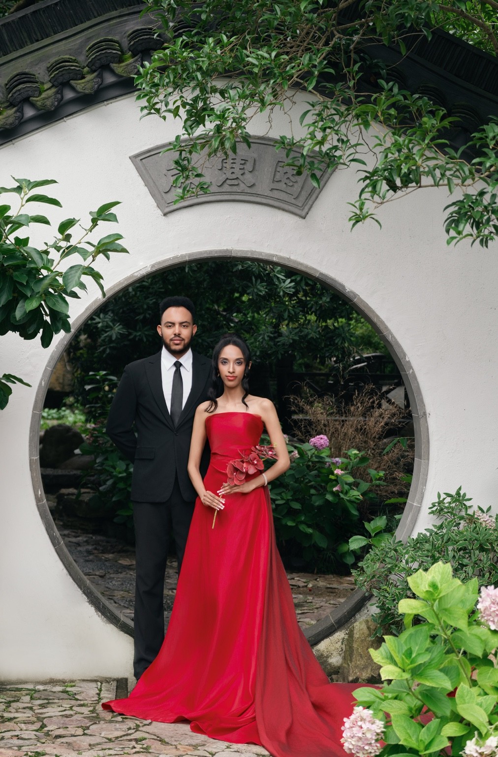 Lydia and Israel standing together in a circular garden arch