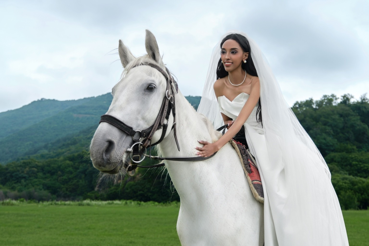 Lydia in a bridal gown on a white horse