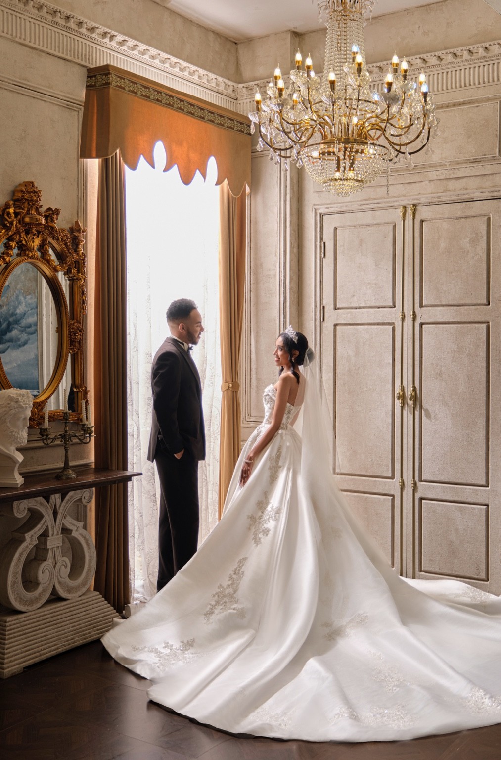Lydia and Israel in elegant wedding attire indoors